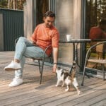 young-man-sitting-outside-petting-his-ca