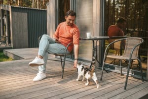 young-man-sitting-outside-petting-his-ca