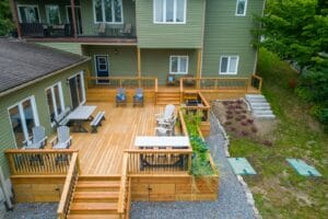 a-deck-with-chairs-and-tables-on-it-next-to-a-house
